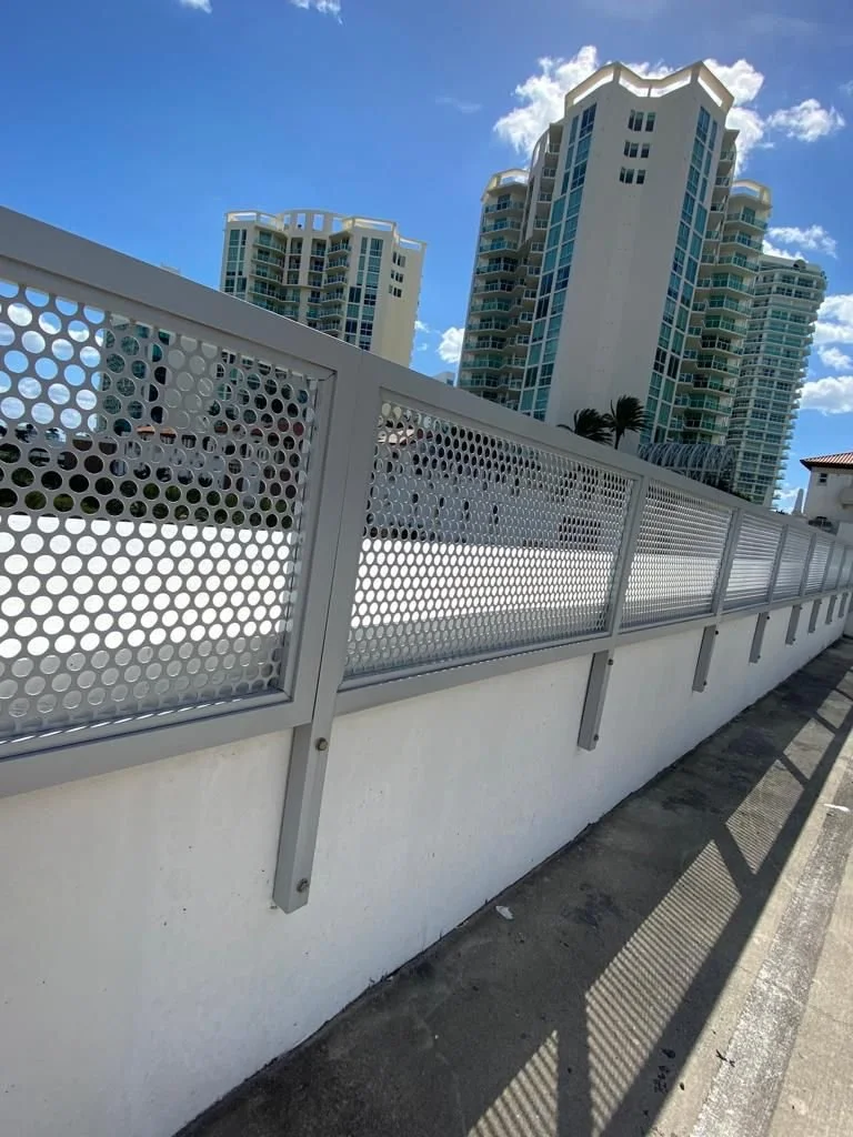 White metal fence with geometric perforated panels