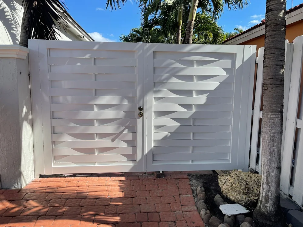White double gate with horizontal slats at a residential entrance