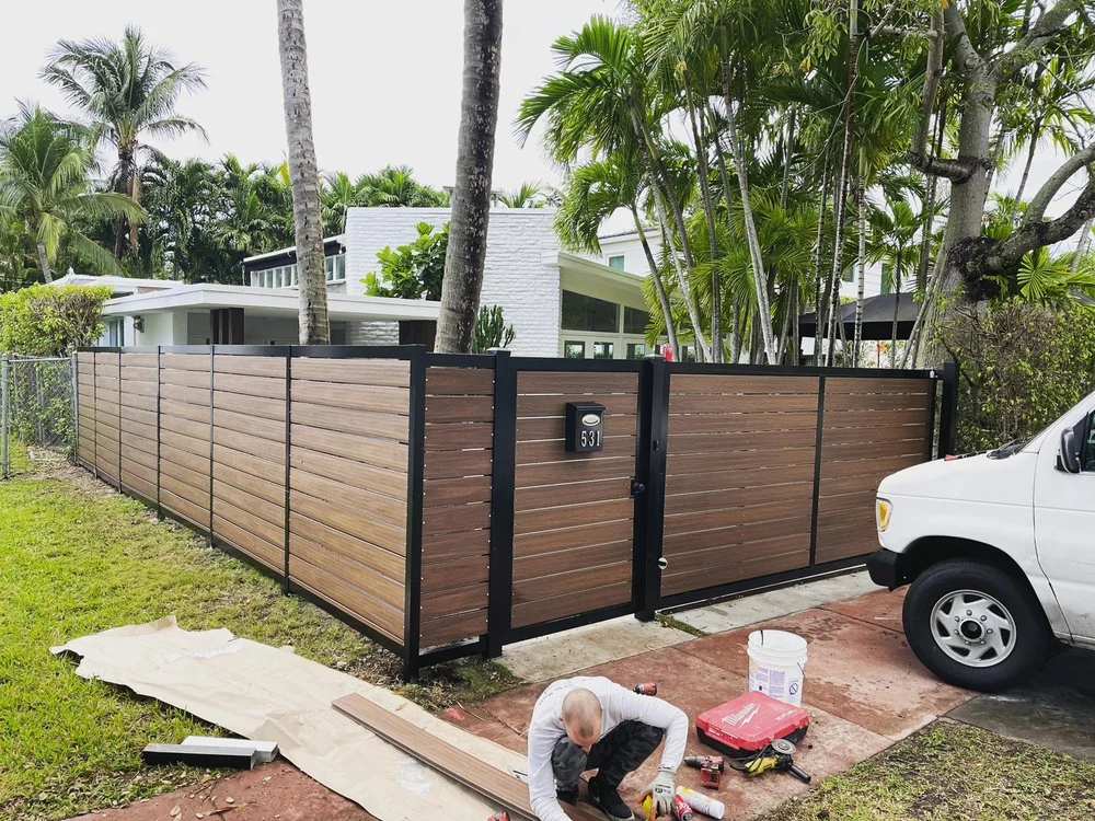 Horizontal wood-look fencing with black metal framing and a pedestrian gate